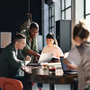 Young professionals or students collaborating in a bright, contemporary co-working environment, displaying teamwork and productivity.